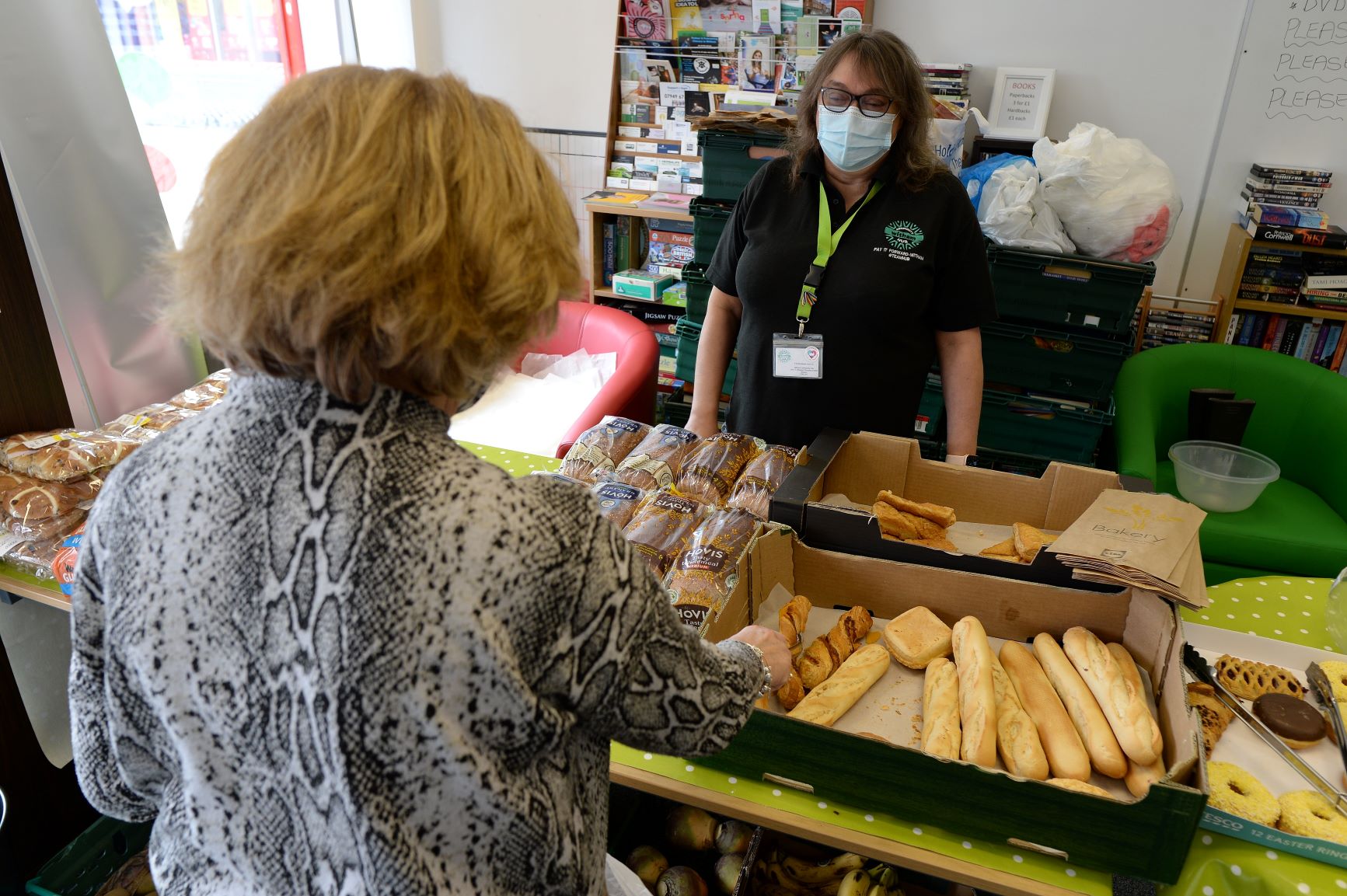 Lady choosing bread and selection of bakery items from the Witham Hub
